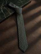 Evergreen green floral tie knotted on dark marble