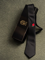 Red Rose black satin tie with red rose detail draped over a black gift box